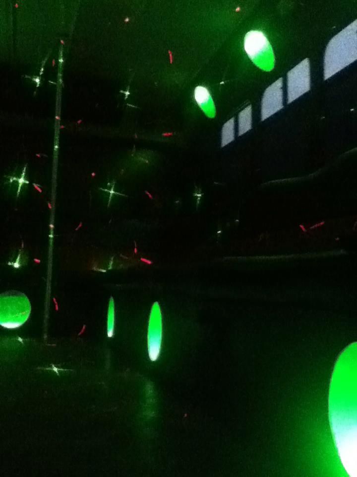 Dark interior with glowing green lights and reflections on a glossy floor, like a laser light show