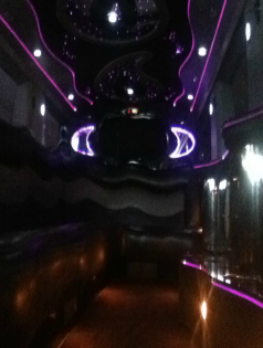 Dark lounge interior with neon purple lights and a glossy reflective ceiling or wall.