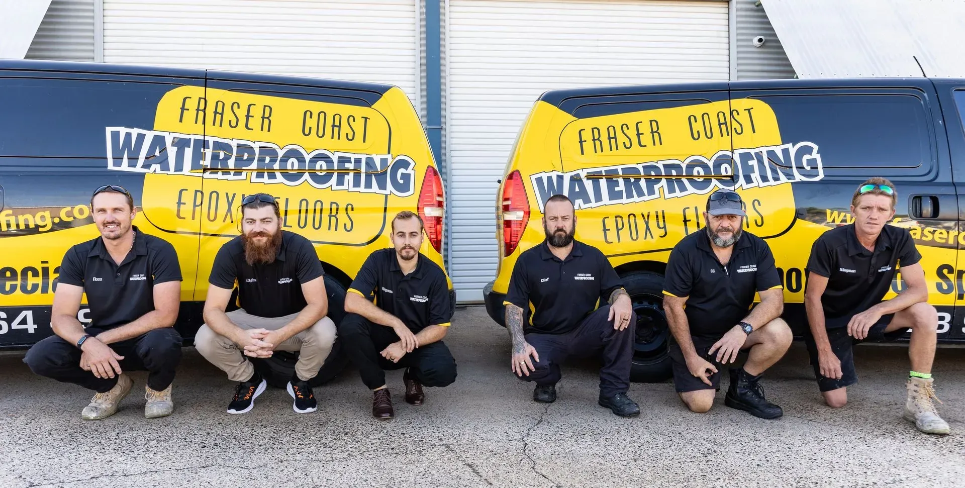 Waterproofing team posing for a picture in front of two vans — Fraser Coast Waterproofing in Pialba, QLD