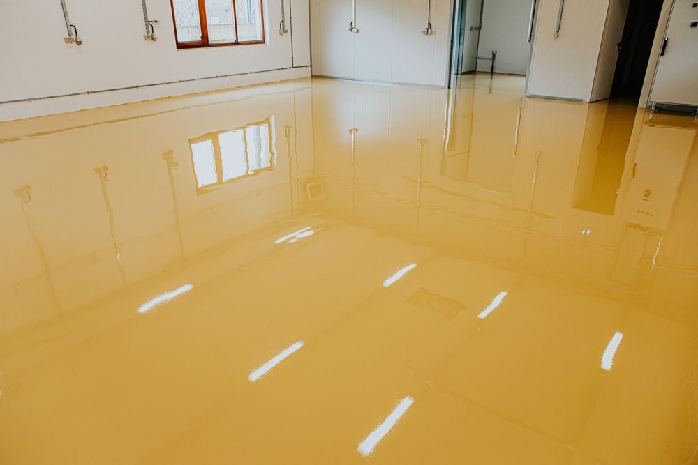 A Room with A Yellow Epoxy Floor and White Walls — Fraser Coast Waterproofing in Torquay, QLD