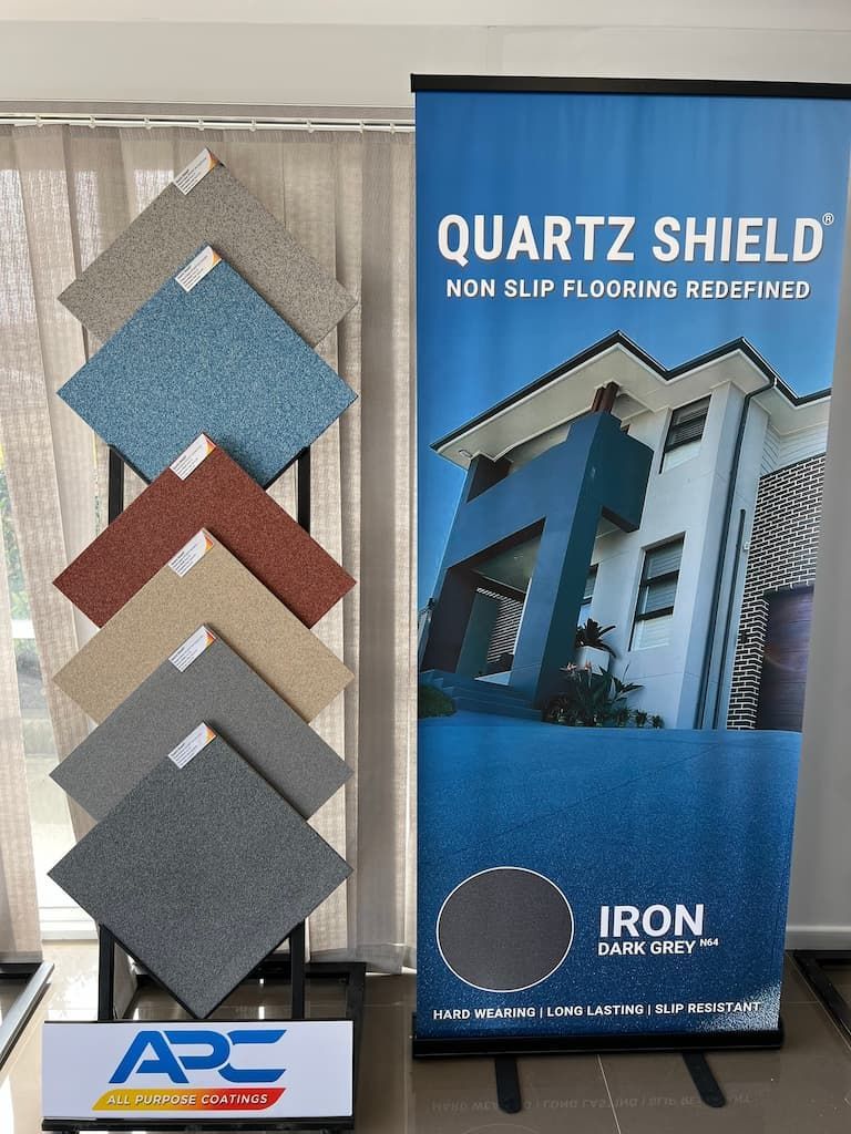 A Display of Tiles Next to a Sign That Says 'Quartz Shield' — Fraser Coast Waterproofing in Pialba, QLD