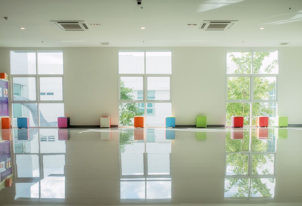 A Large Room with A Lot of Windows and Colourful Ottomans — Fraser Coast Waterproofing in Pialba, QLD