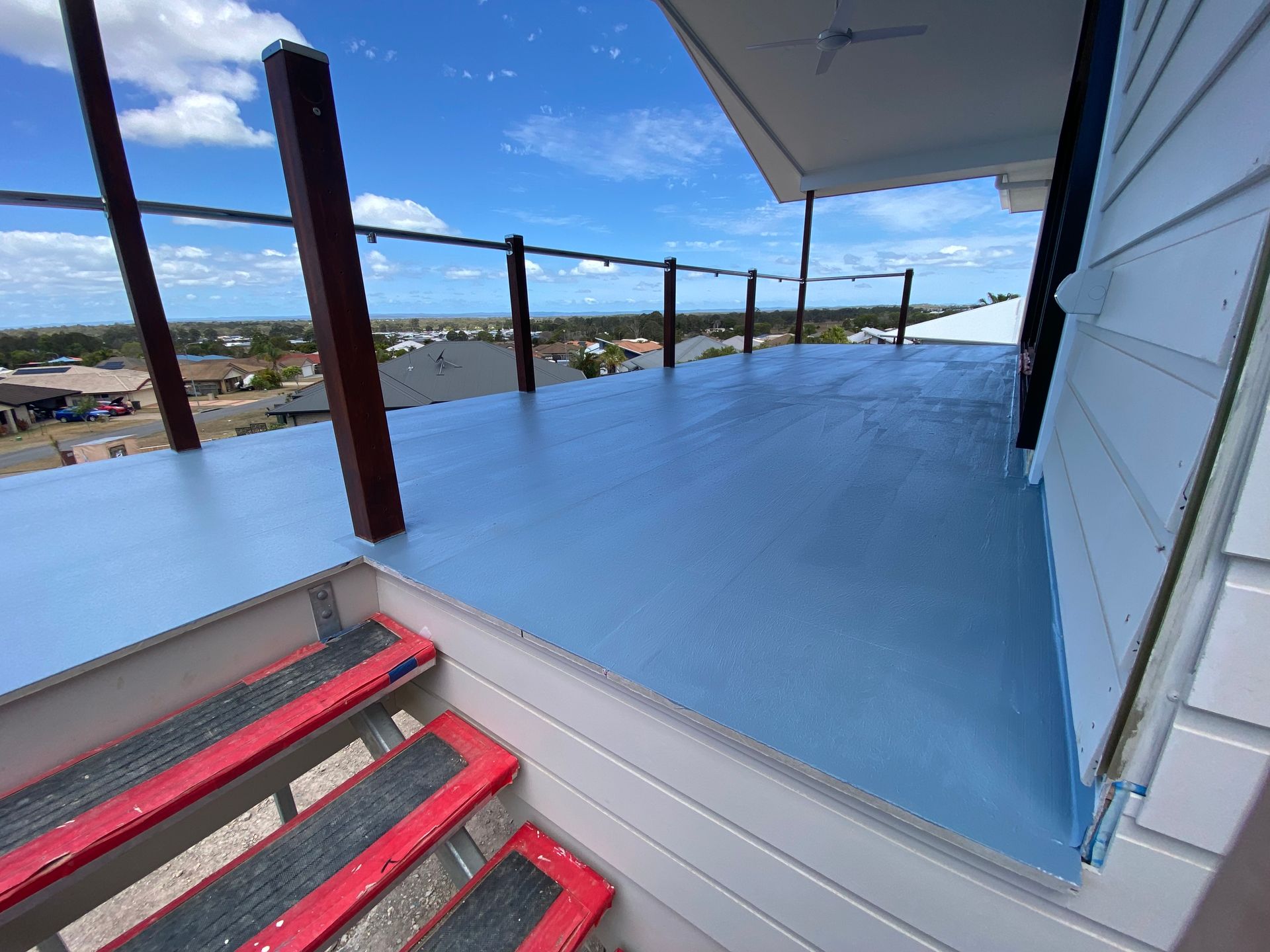 A Large Black Wall Is Surrounded by An Orange Fence — Fraser Coast Waterproofing in Pialba, QLD