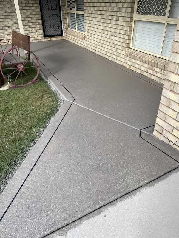 A Brick House with A Concrete Porch and A Wheelbarrow in Front of It — Fraser Coast Waterproofing in Pialba, QLD