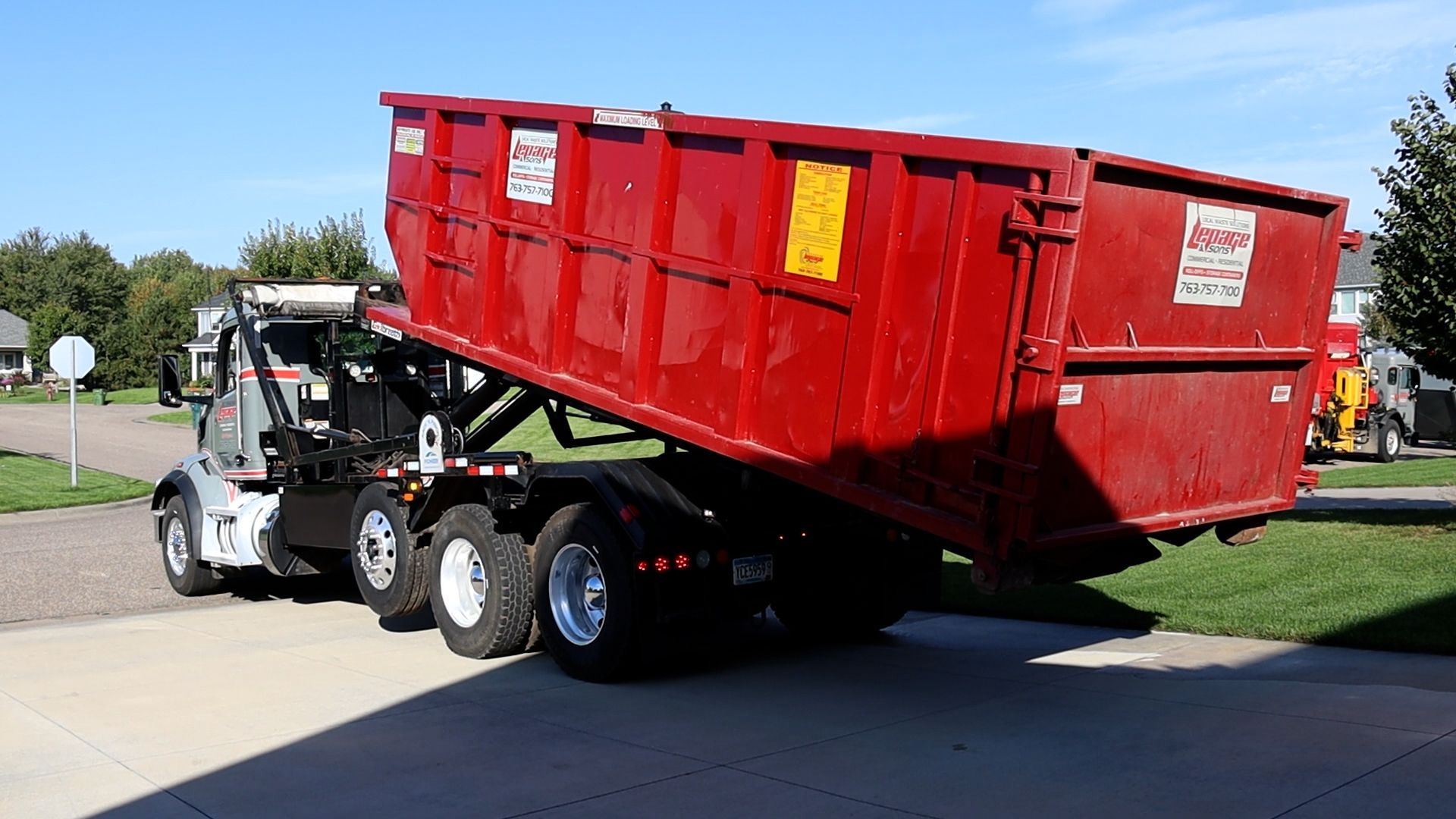 LePage & Sons delivers a roll-off dumpster rental to a residential home.