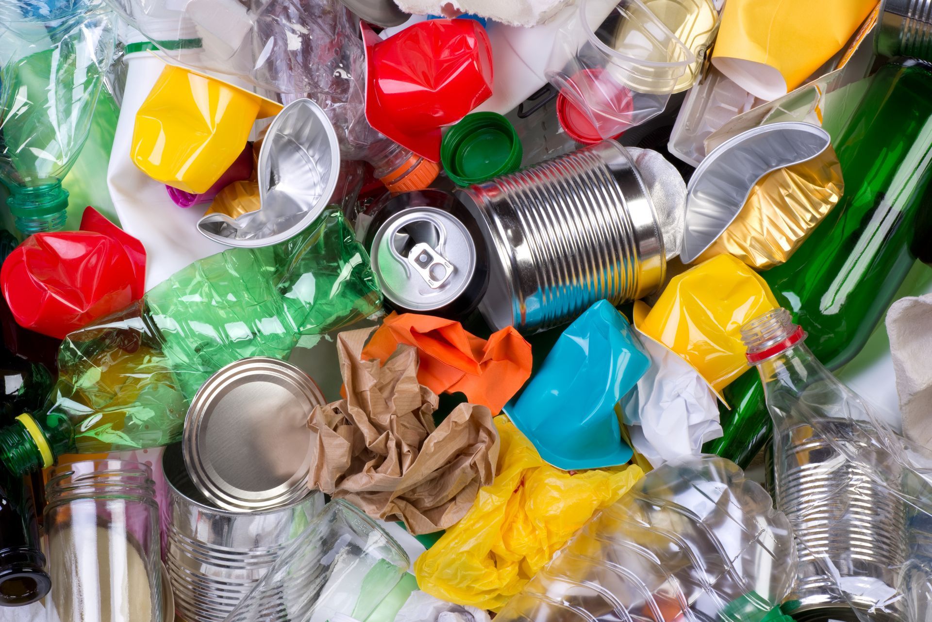Pile of assorted recyclables: cans, bottles, and plastic containers.