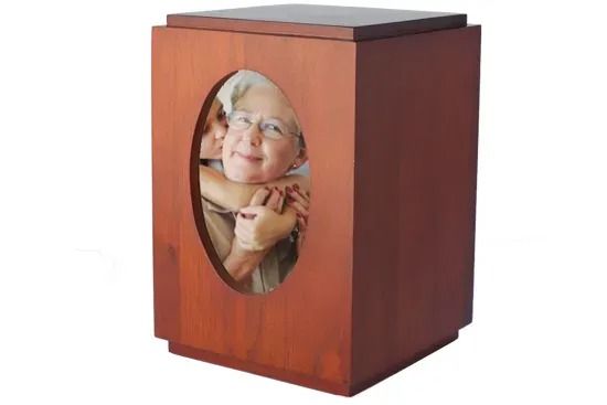 Wooden cremation urn with an oval photo of a smiling person on the front