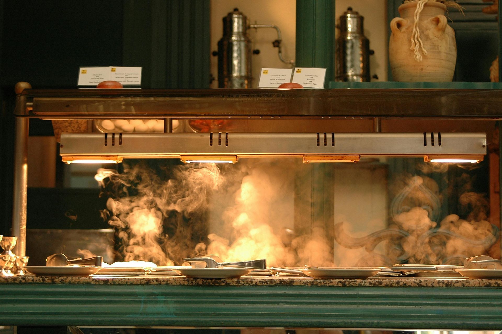 A buffet line in a restaurant with smoke coming out of it