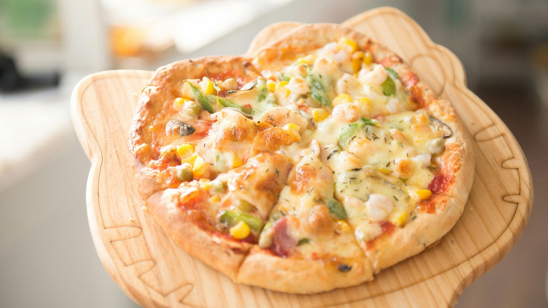 A pizza is sitting on top of a wooden cutting board.