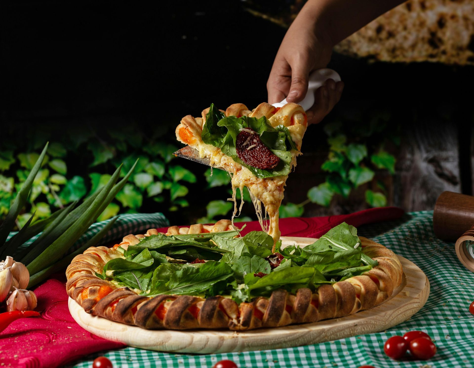 A person is taking a slice of pizza from a pizza.