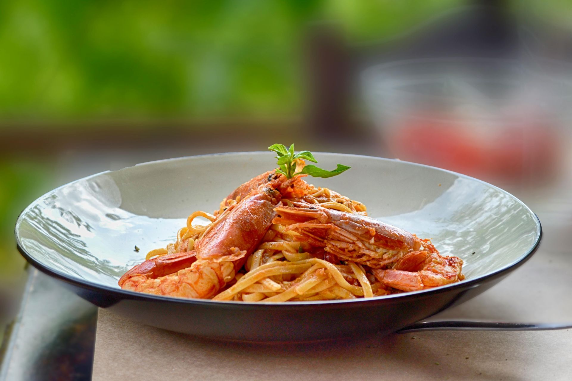 A plate of spaghetti with shrimp on a table.
