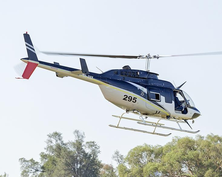 Blue and white helicopter in flight, with number