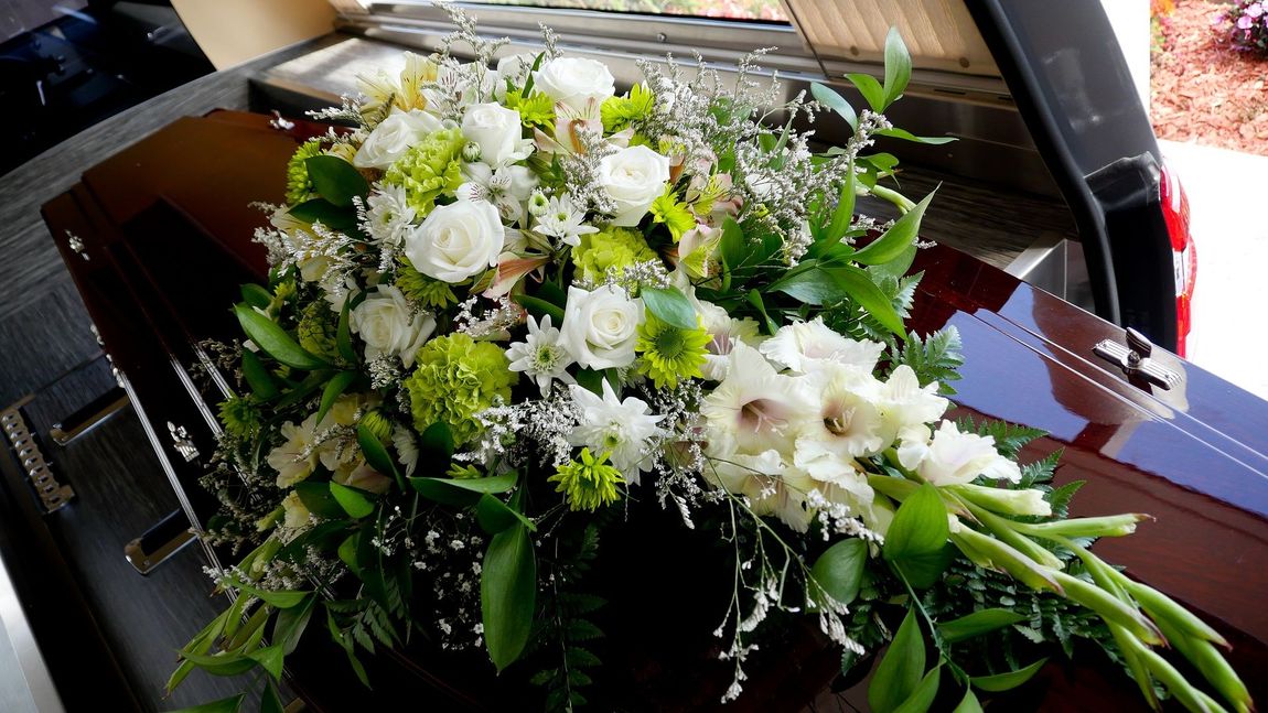 trasporto funebre di cassa con fiori
