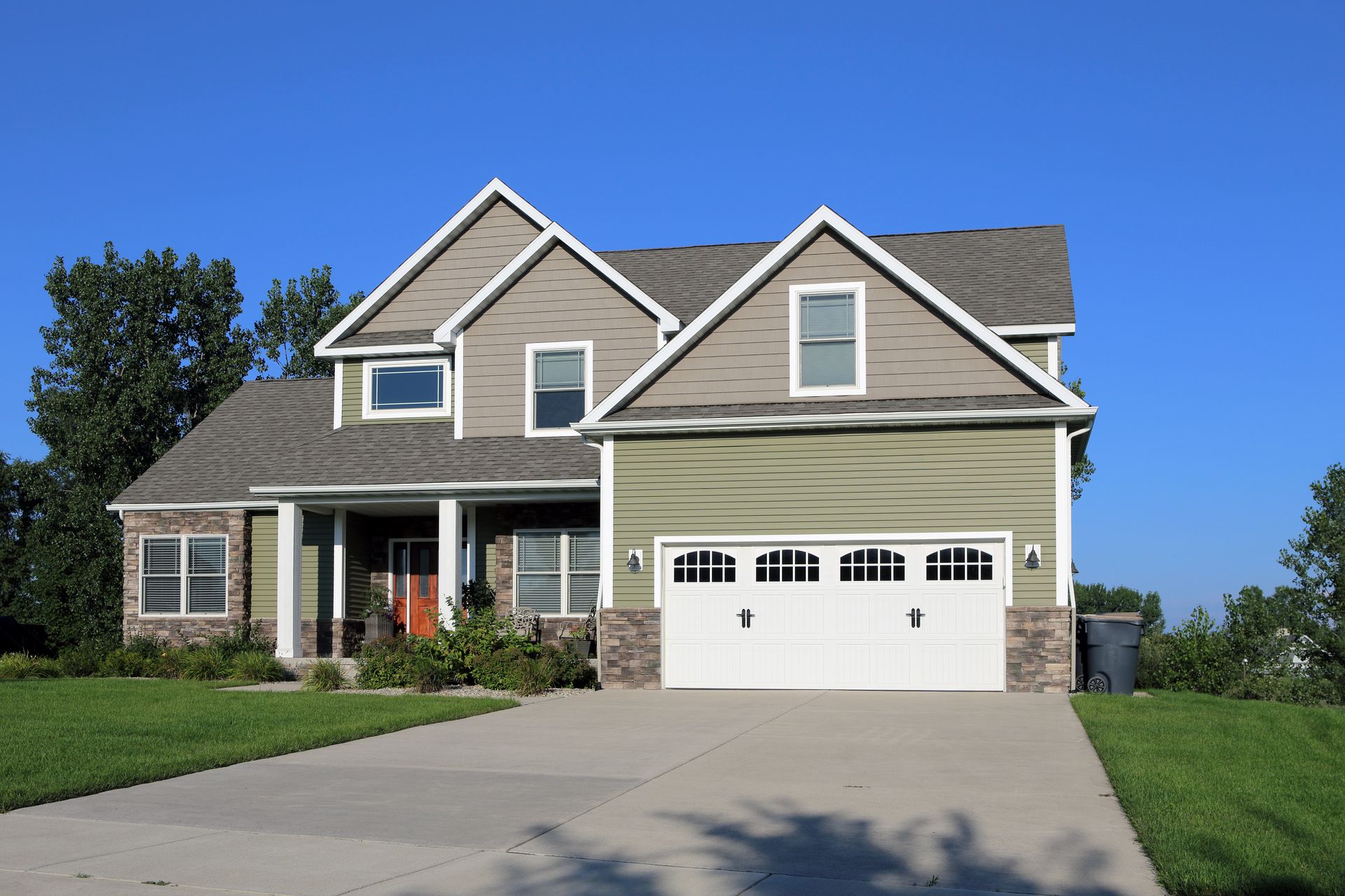 White double garage door with arched windows on a house exterior