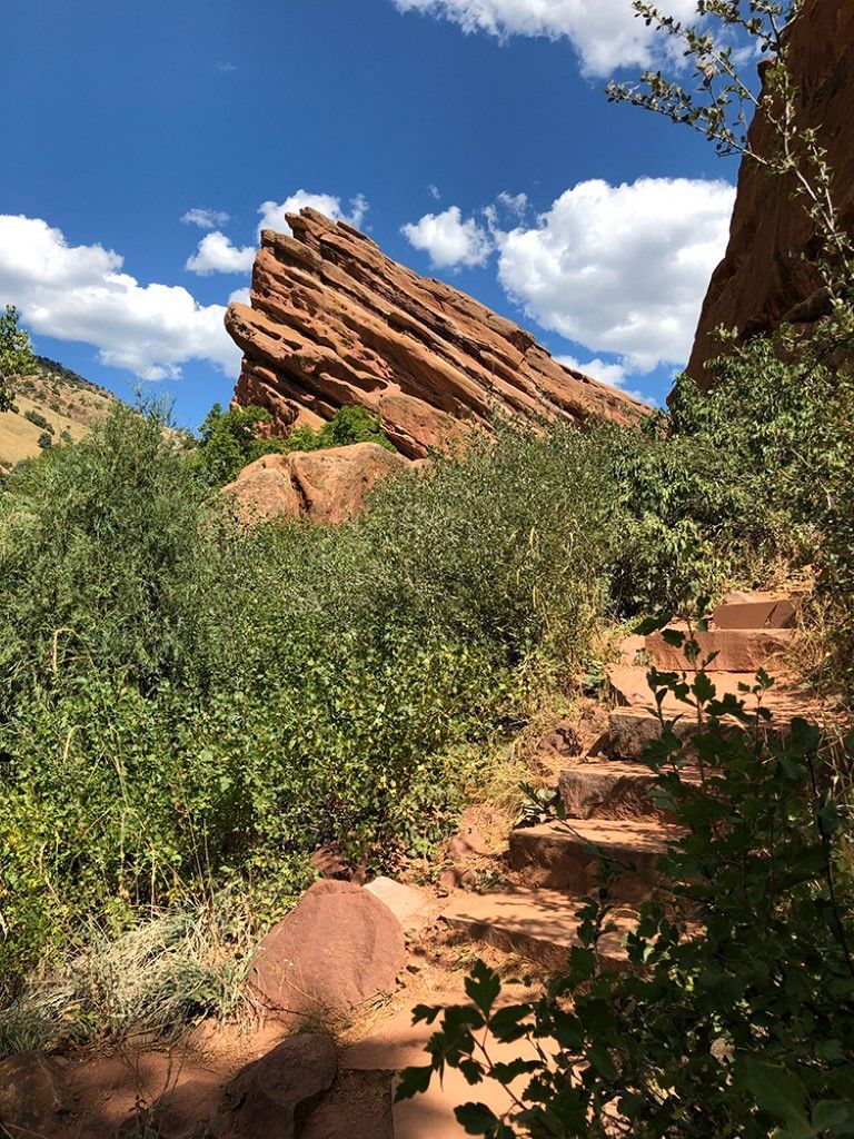 Path to a grand rock formation beneath a clear blue sky