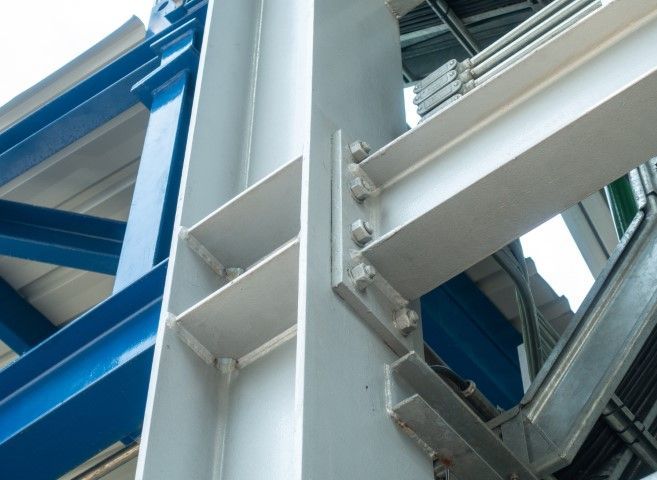 Bolted steel connection against blue and white walls