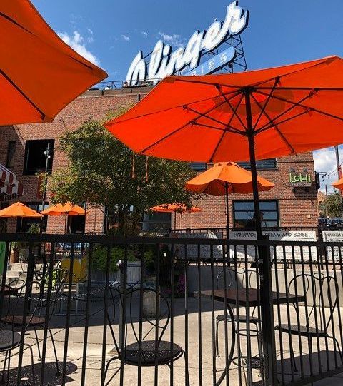 Red umbrellas and sign on a peaceful outdoor patio with handrails.