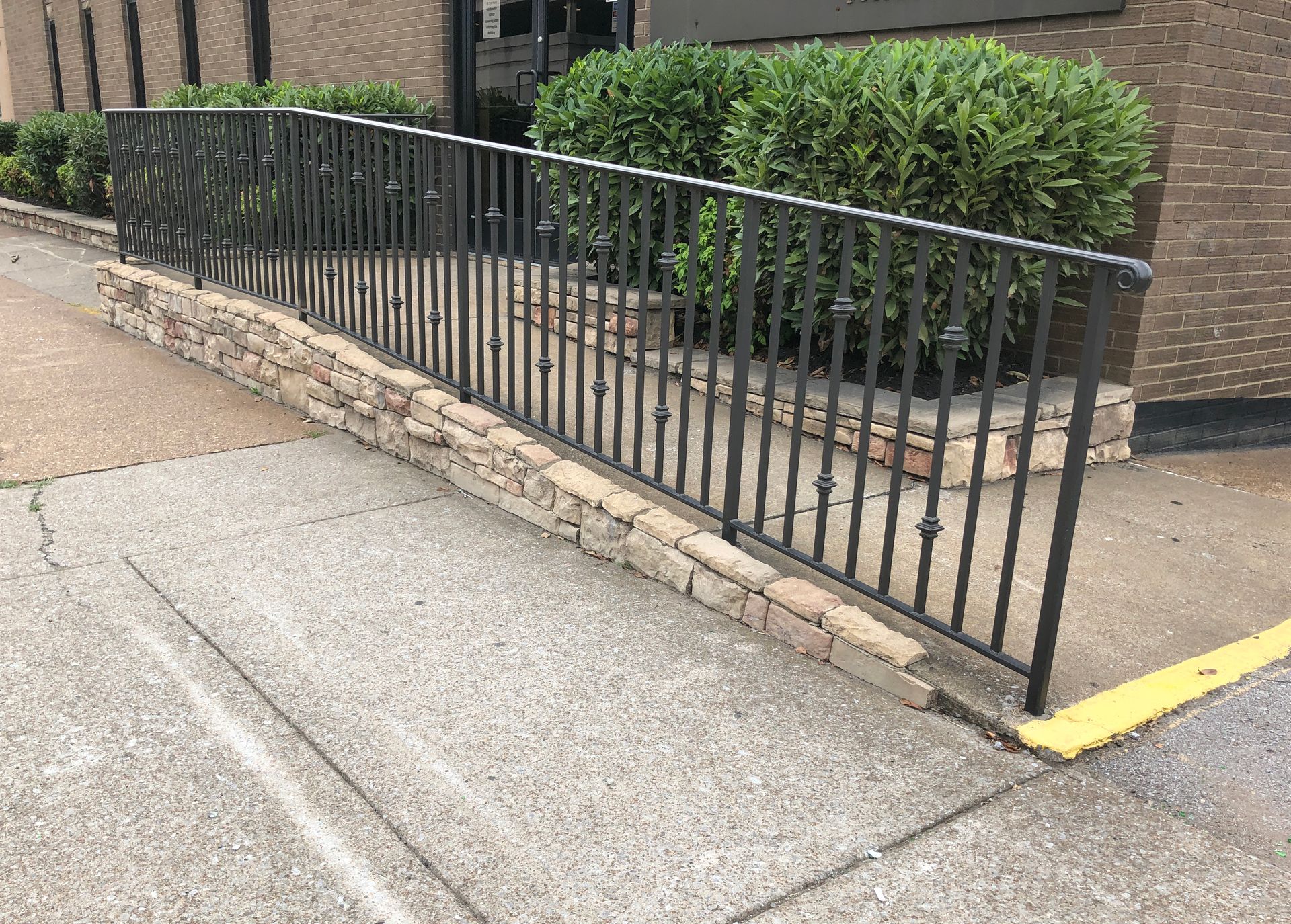 Exterior handrail in brown powder-coat at office building entrance