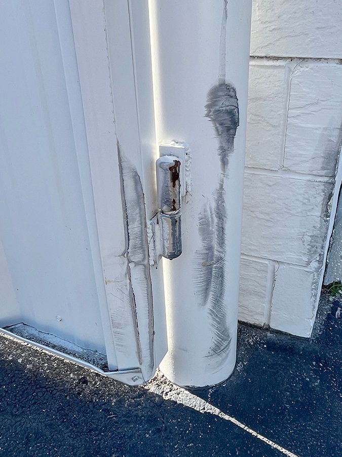 damaged dumpster gate hinge in need of repair