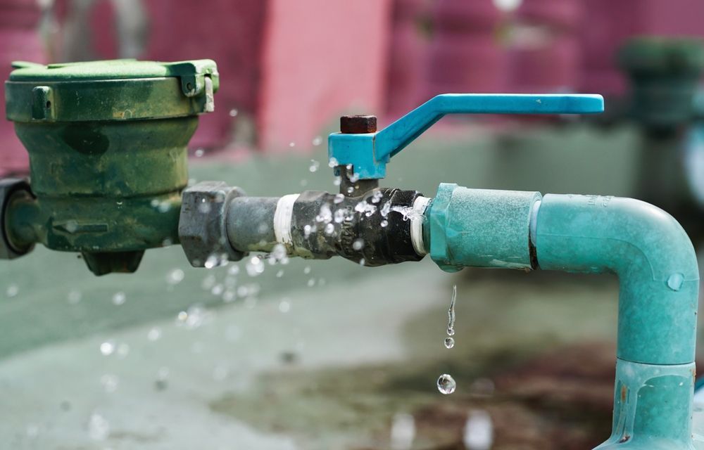 Water Leaking from Pipe with Blue Valve and Water Meter — Weav Plumbed in Emerald, QLD