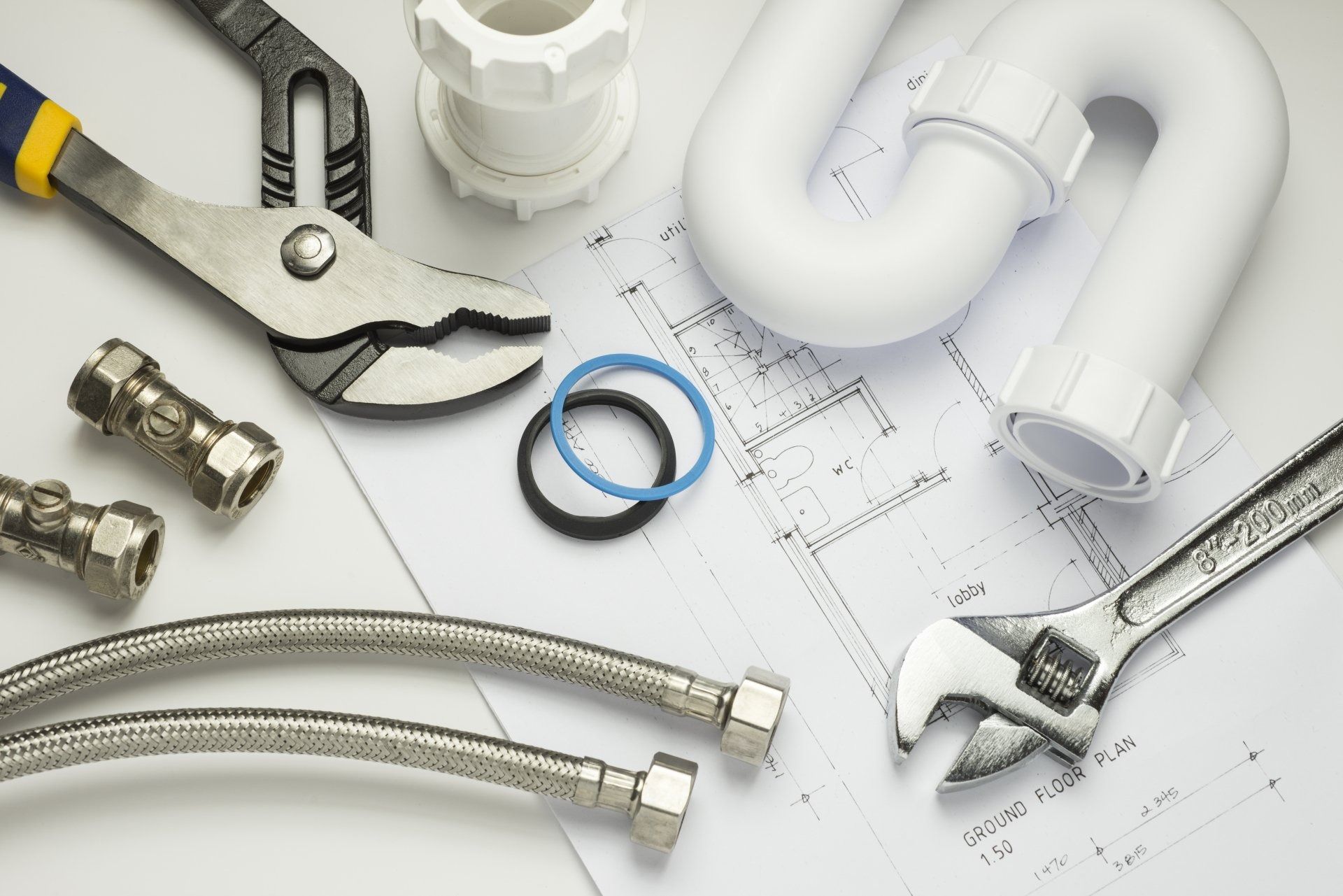 Plumbing Tools and Parts: Wrench, Pliers, Pipes, Fittings, and A Blueprint — Weav Plumbed in Emerald, QLD