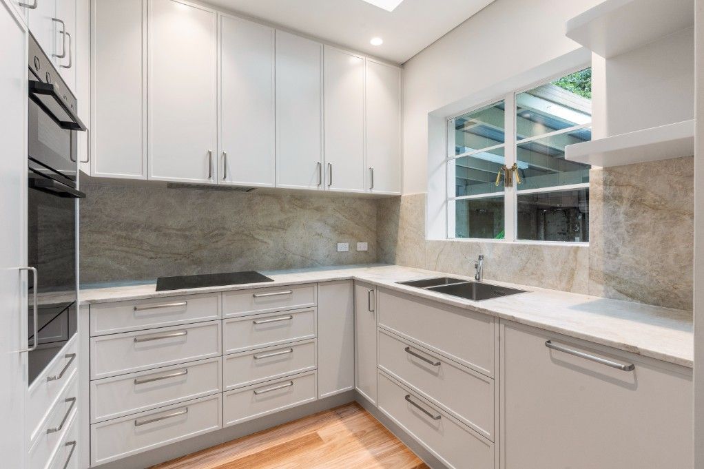 A Newly Renovated Kitchen With White Cabinets
