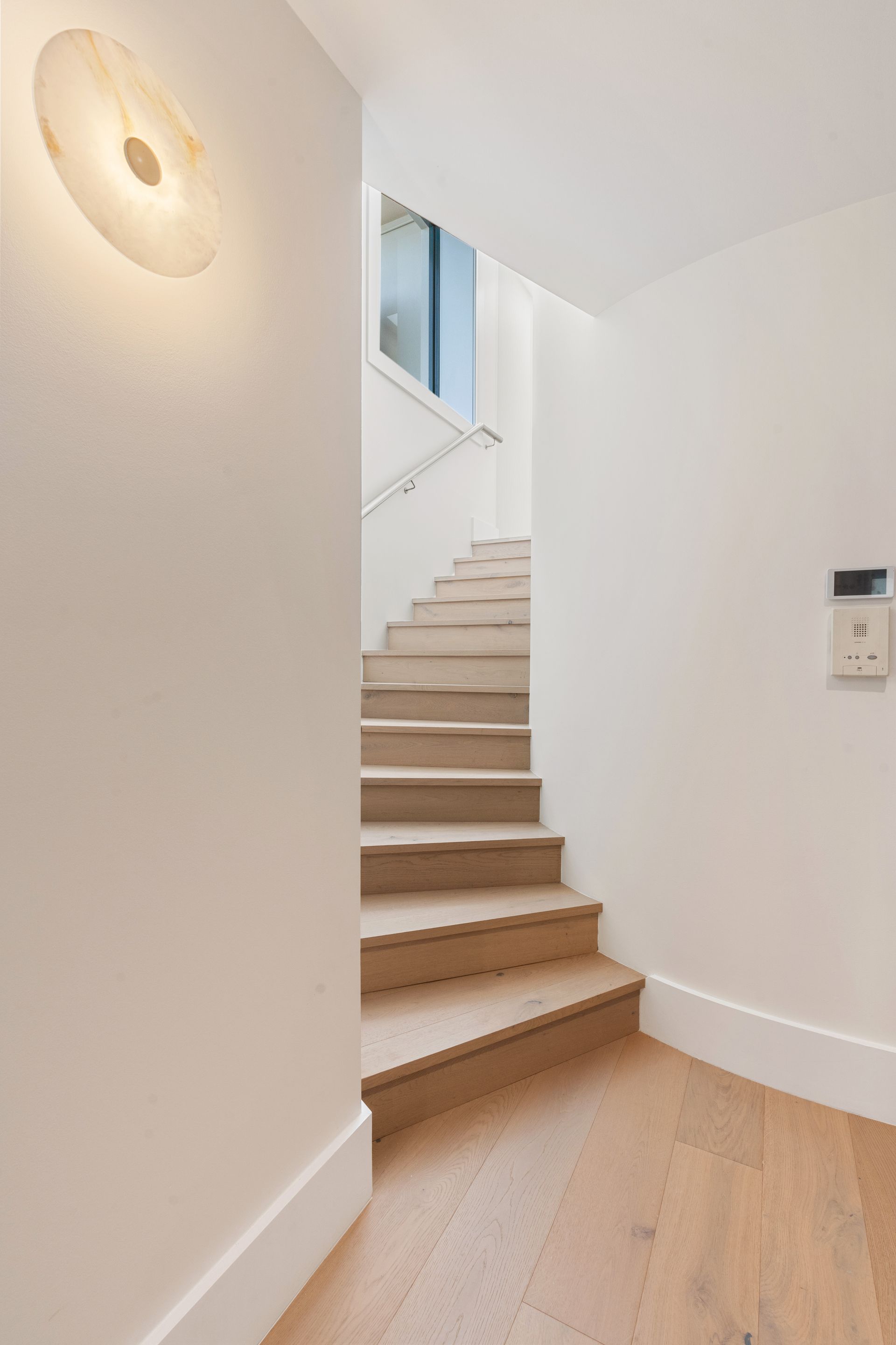 A White Interior Hallway With Light Wood Stairs Leading Upward — ATH Projects in Sutherland Shire, NSW