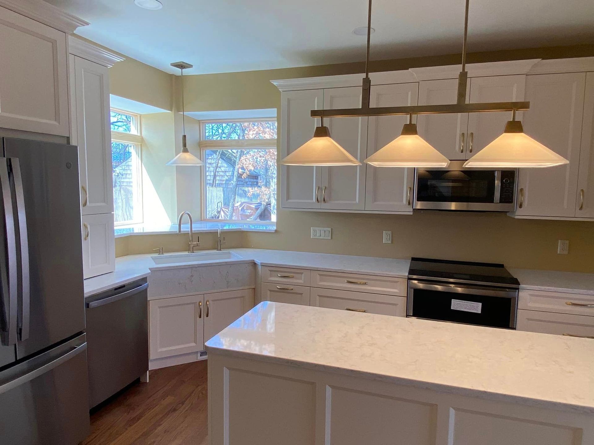 A & R Home Services remodel  kitchen with white cabinets , stainless steel appliances and a large island.