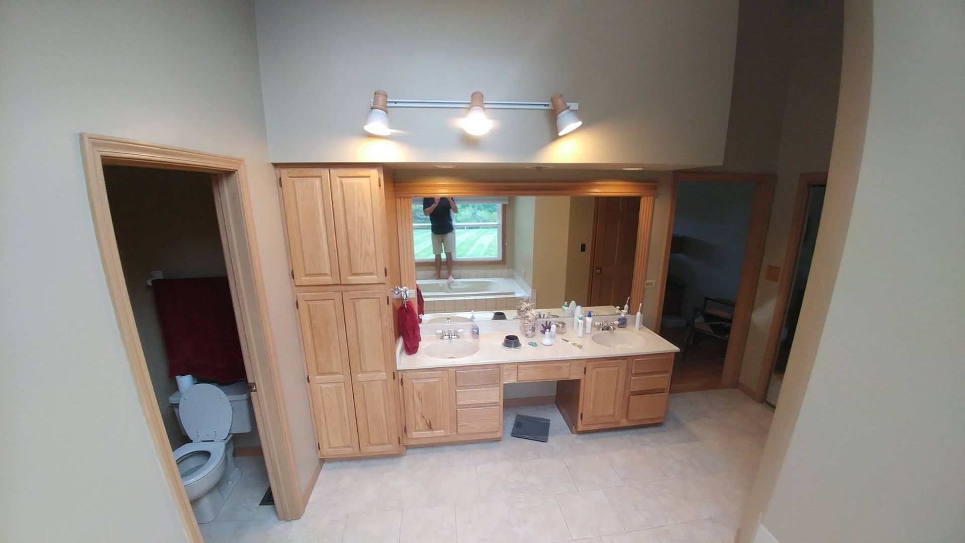 A & R Home Services remodel bathroom with two sinks , a toilet , and a large mirror.