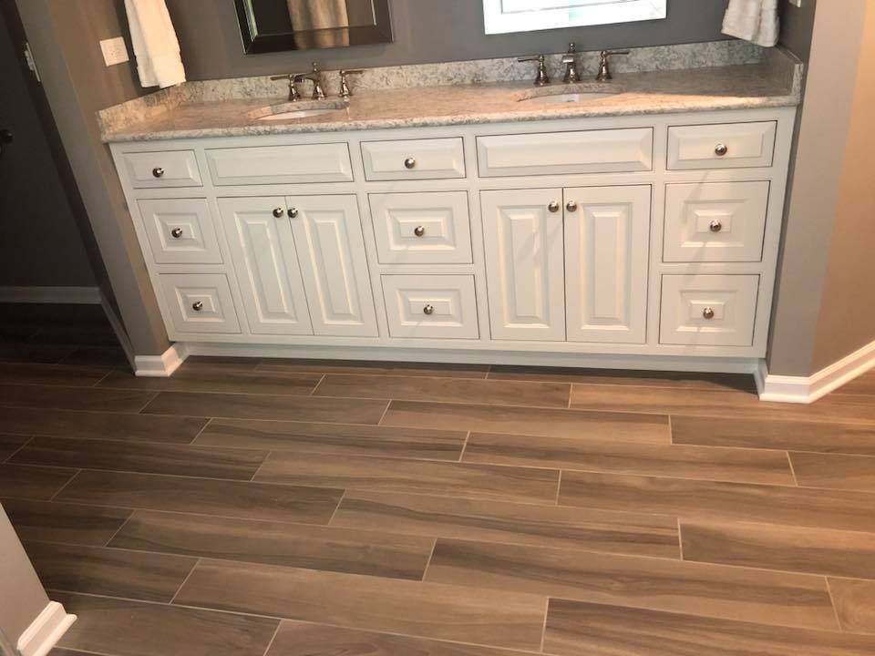 A & R Home Services remodel bathroom with two sinks and a tiled floor.