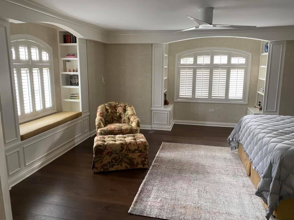 A & R Home Services remodel bedroom with a bed , chair , ottoman and window seat.