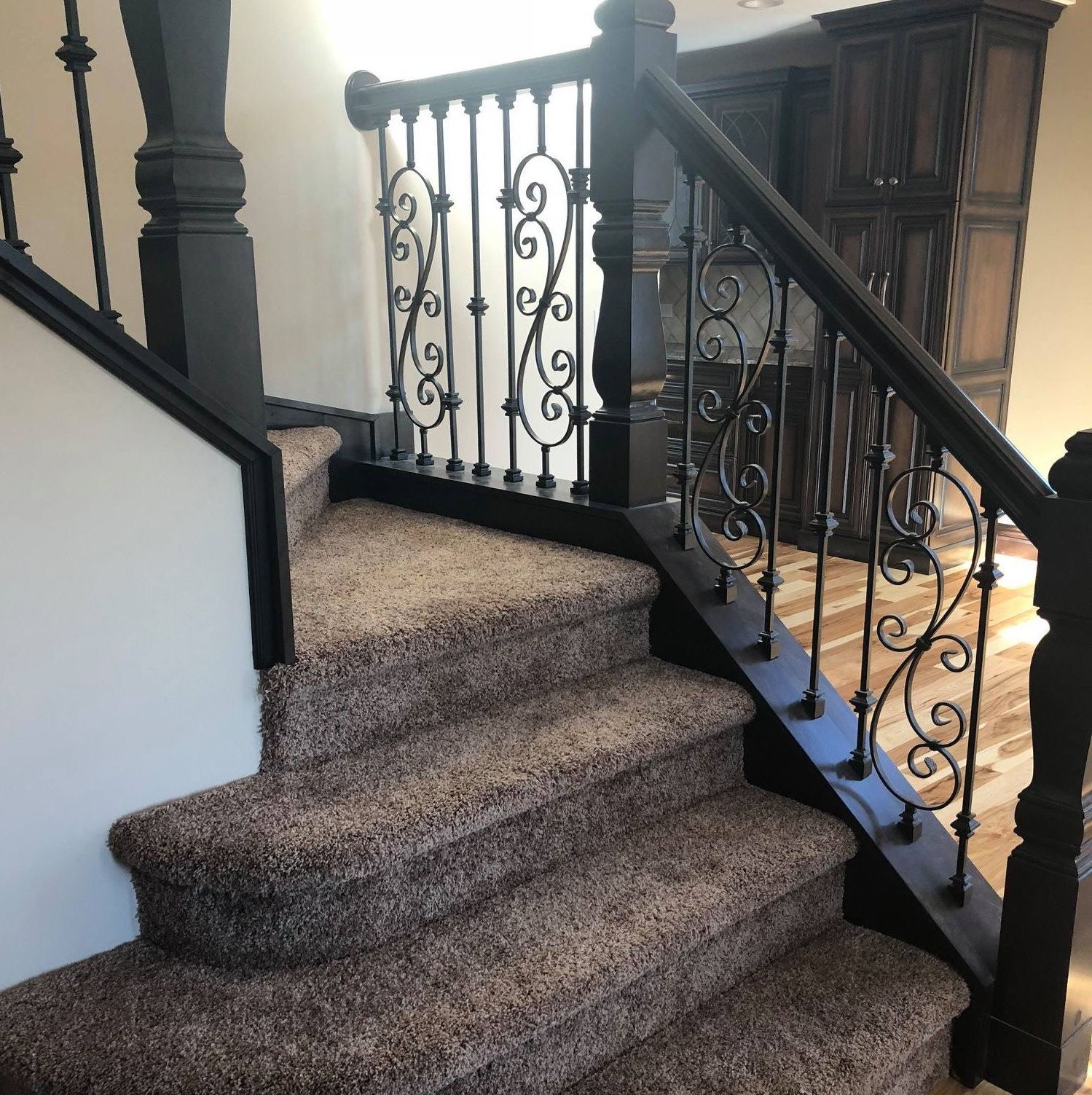 A & R Home Services remodel staircase with a wrought iron railing and carpeted steps