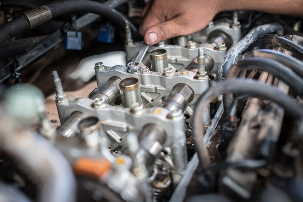 A Close Up Of A Person Working On A Car Engine — Carite Auto Repairs In Warana, QLD