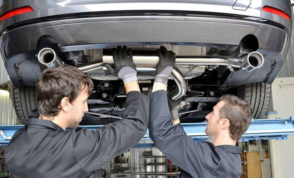 Two men are working on the underside of a car. β Carite Auto Repairs In Warana, QLD