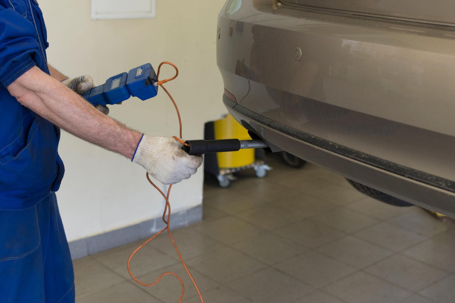 A Man Is Holding A Tool Next To A Car In A Garage β Carite Auto Repairs In Warana, QLD
