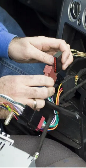 Hands Connecting Wiring in a Car Dashboard With Exposed Electrical Harnesses — Carite Auto Repairs In Warana, QLD