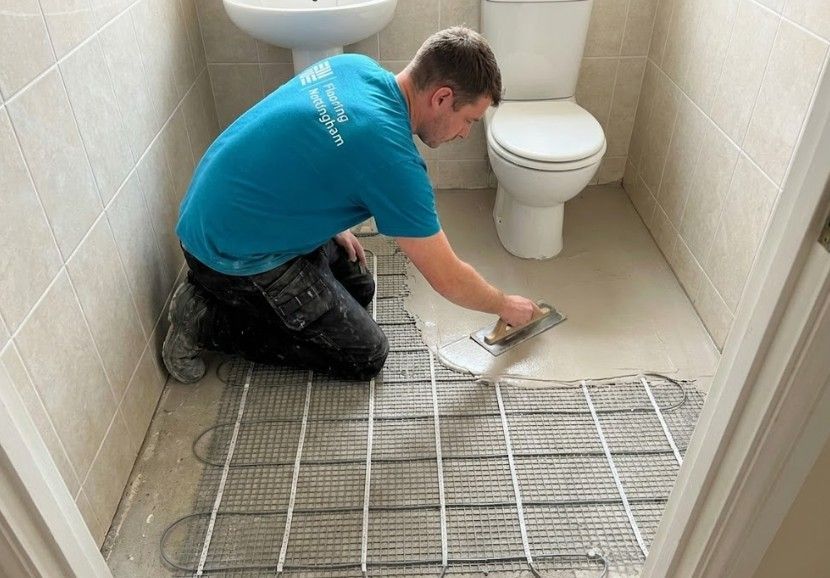 Flooring Nottingham levelling screed over electric underfloor heating wires in a bathroom