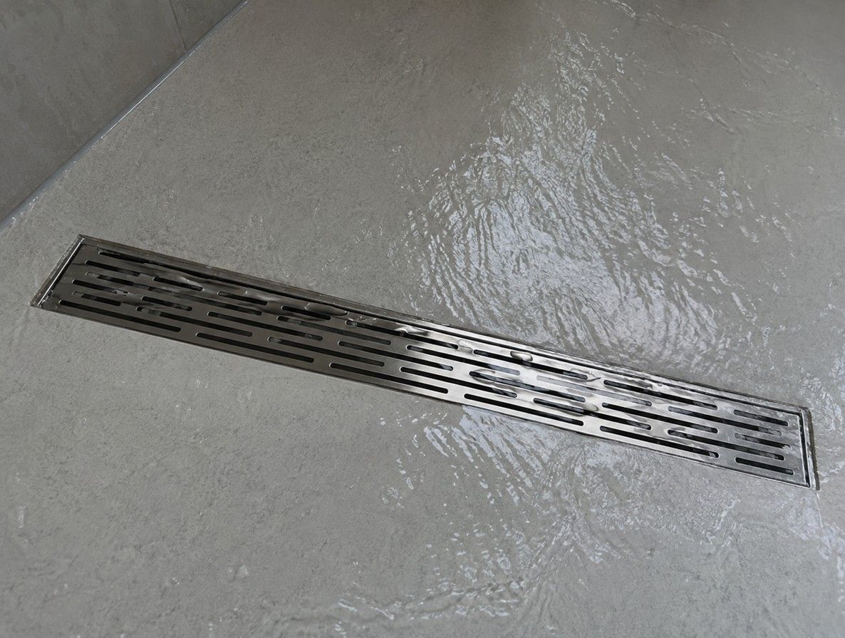 Linear drain set into a wet room floor with a fall towards it