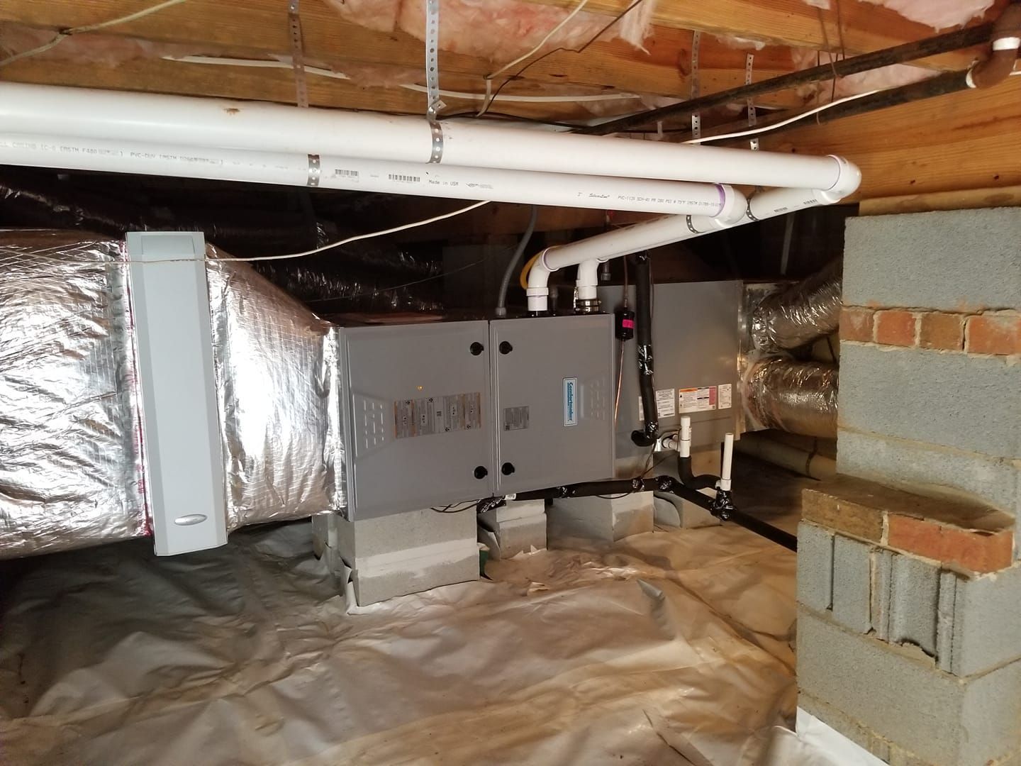 a basement with a heater and pipes in it