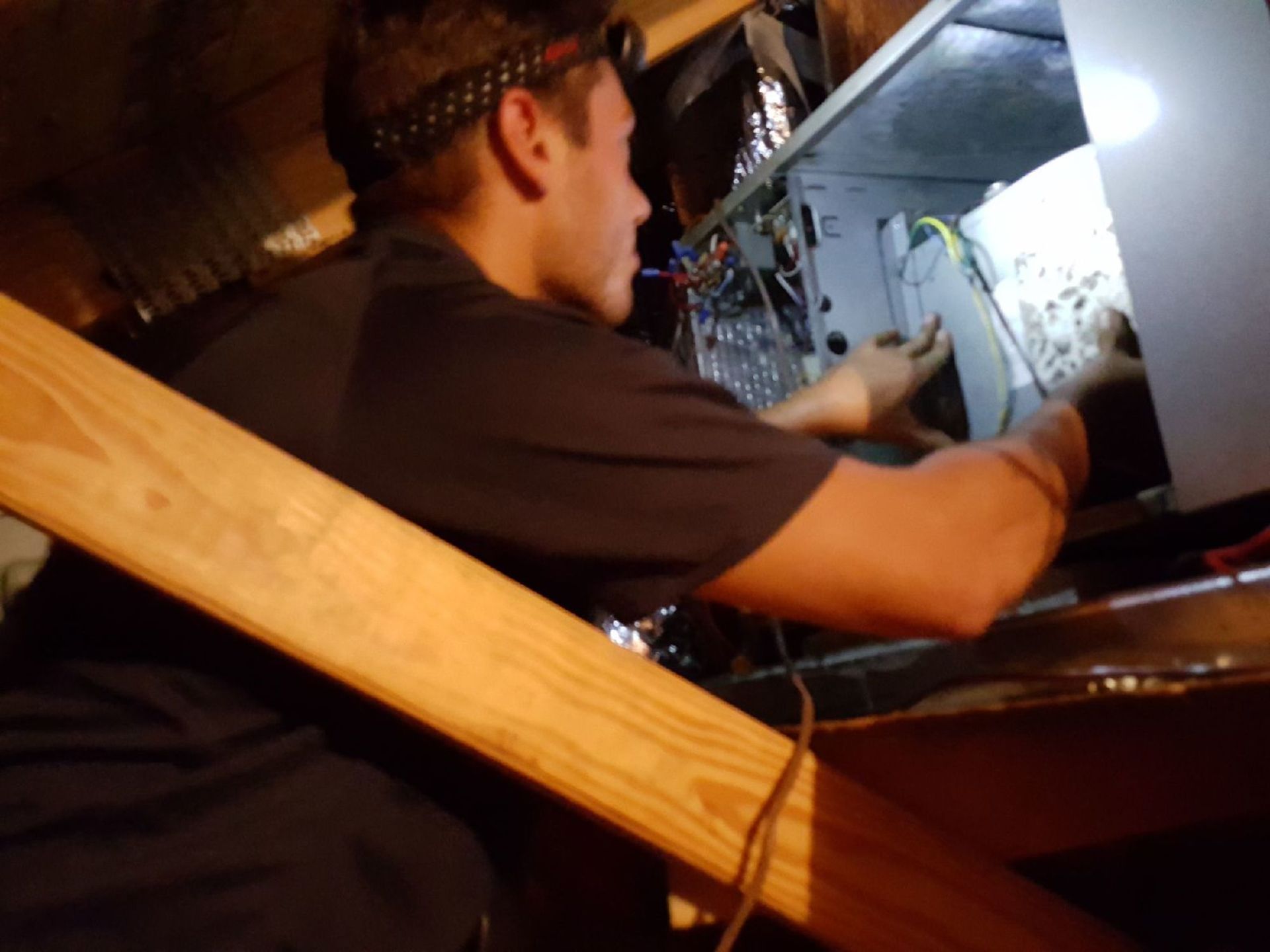 a man is working on a computer in an attic .