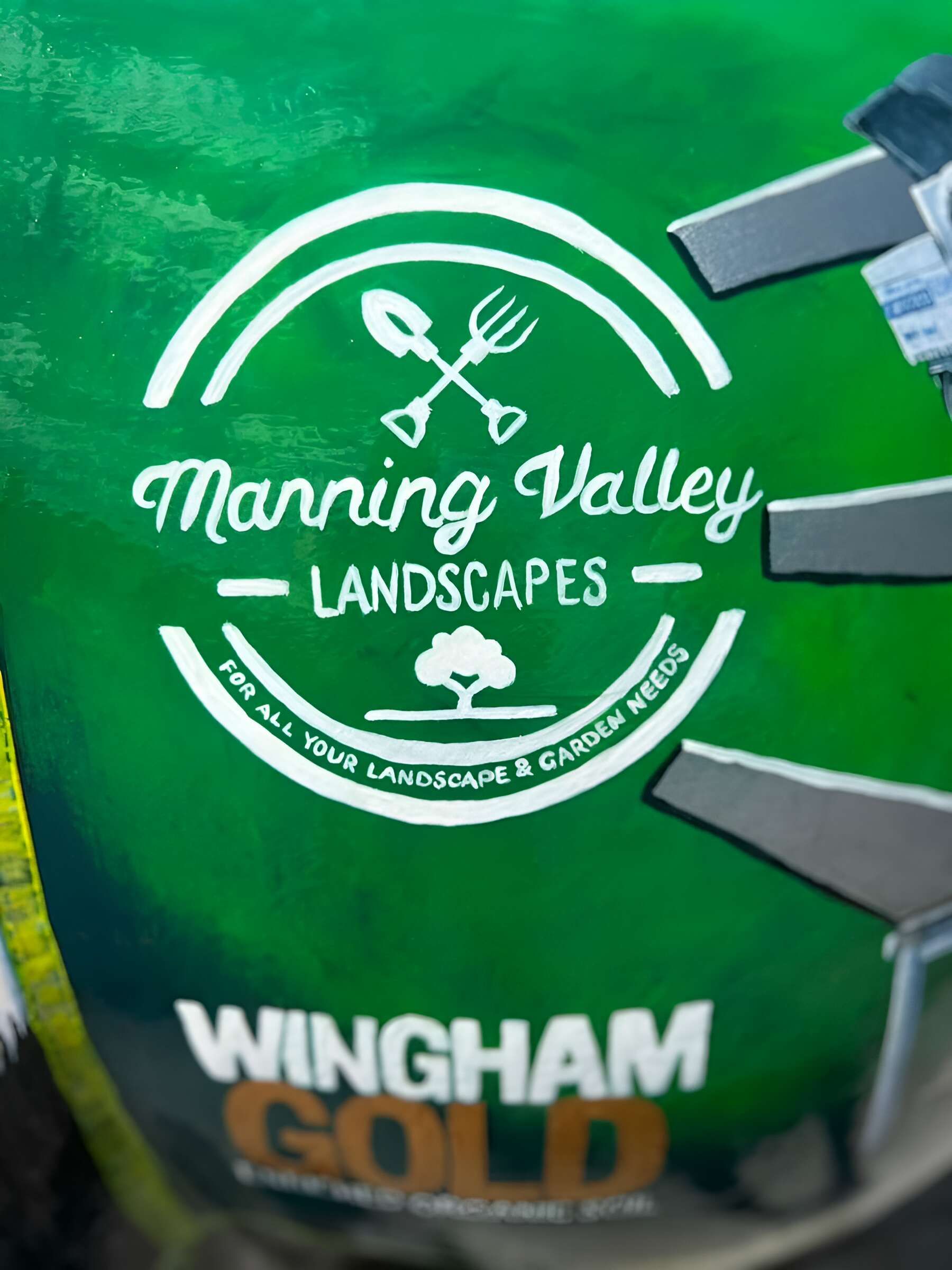 A Manning Valley Landscapes Logo on a Green Background — Manning Valley Landscapes in Wingham, NSW