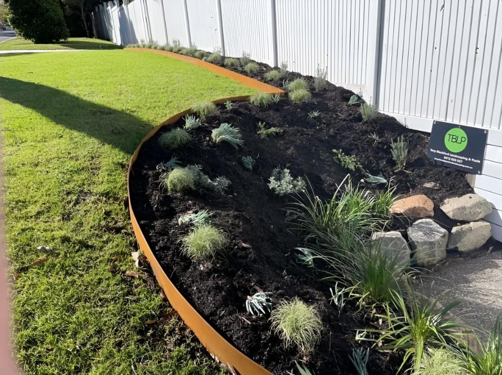 Raised Garden Bed with Rusty Metal Edging and Various Plants — Manning Valley Landscapes in Wingham, NSW