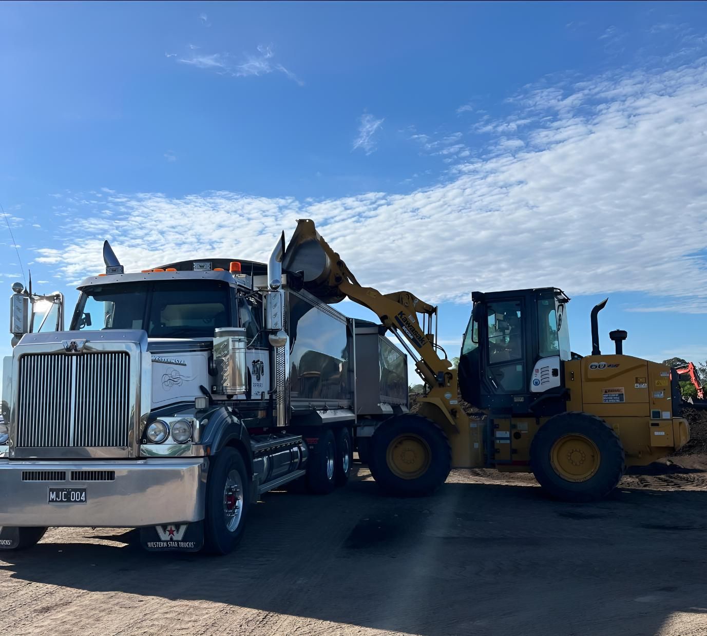 A Semi Truck is Parked Next to a Yellow Bulldozer — Manning Valley Landscapes in Wingham, NSW