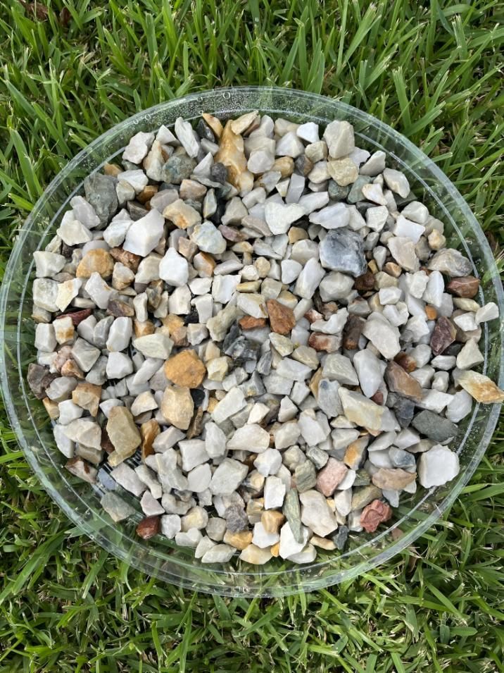 A Glass Bowl Filled With Rocks is Sitting on Top of a Lush Green Field — Manning Valley Landscapes in Harrington, NSW