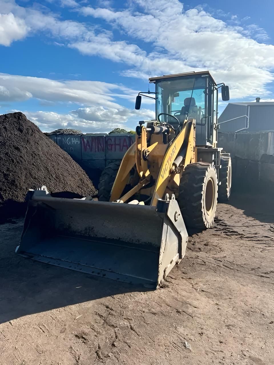 A Bulldozer is Parked in Front of a Pile of Dirt — Manning Valley Landscapes in Wingham, NSW