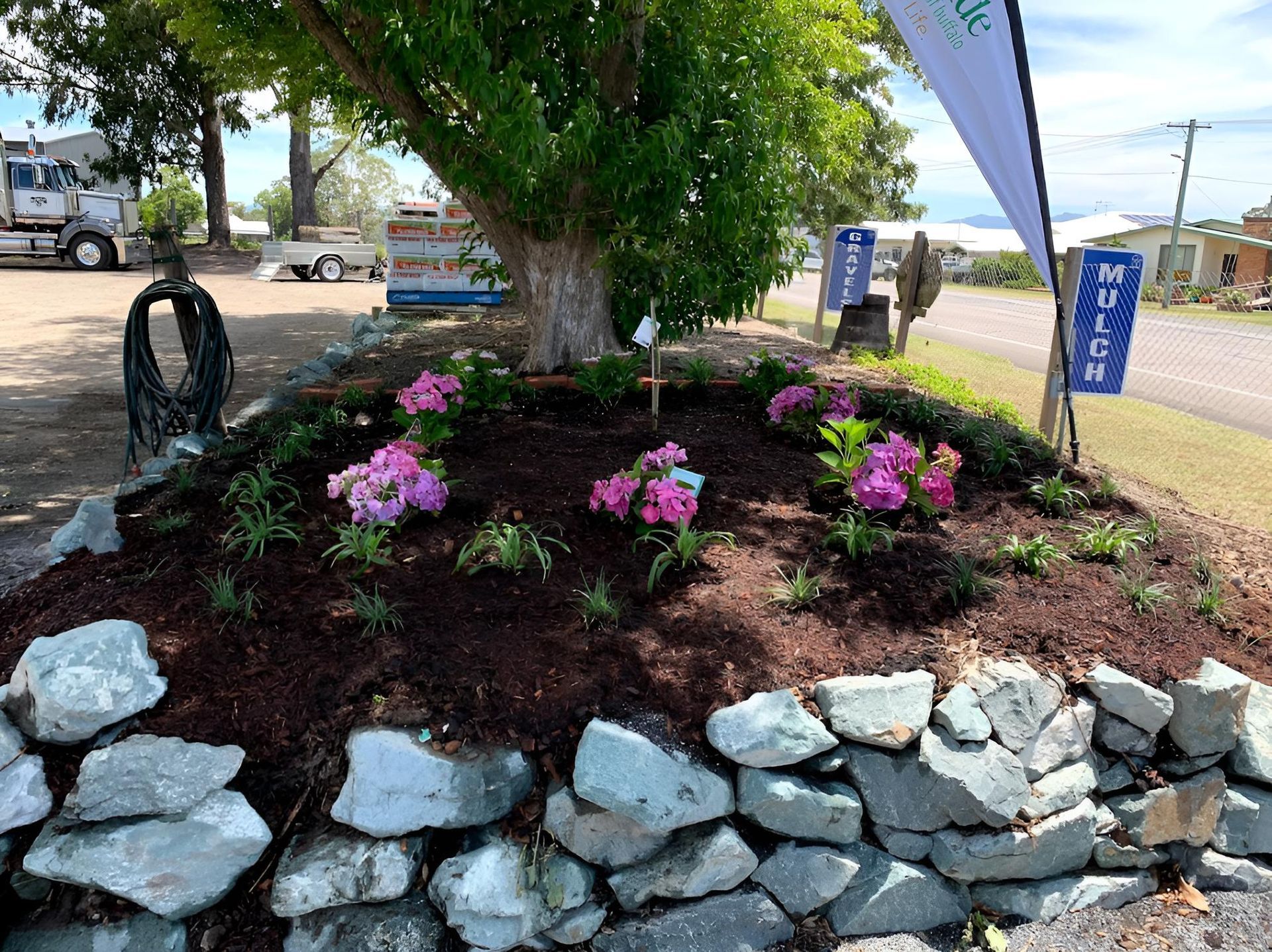 A Rock Garden With Pink Flowers and a Tree in the Background — Manning Valley Landscapes in Forster, NSW