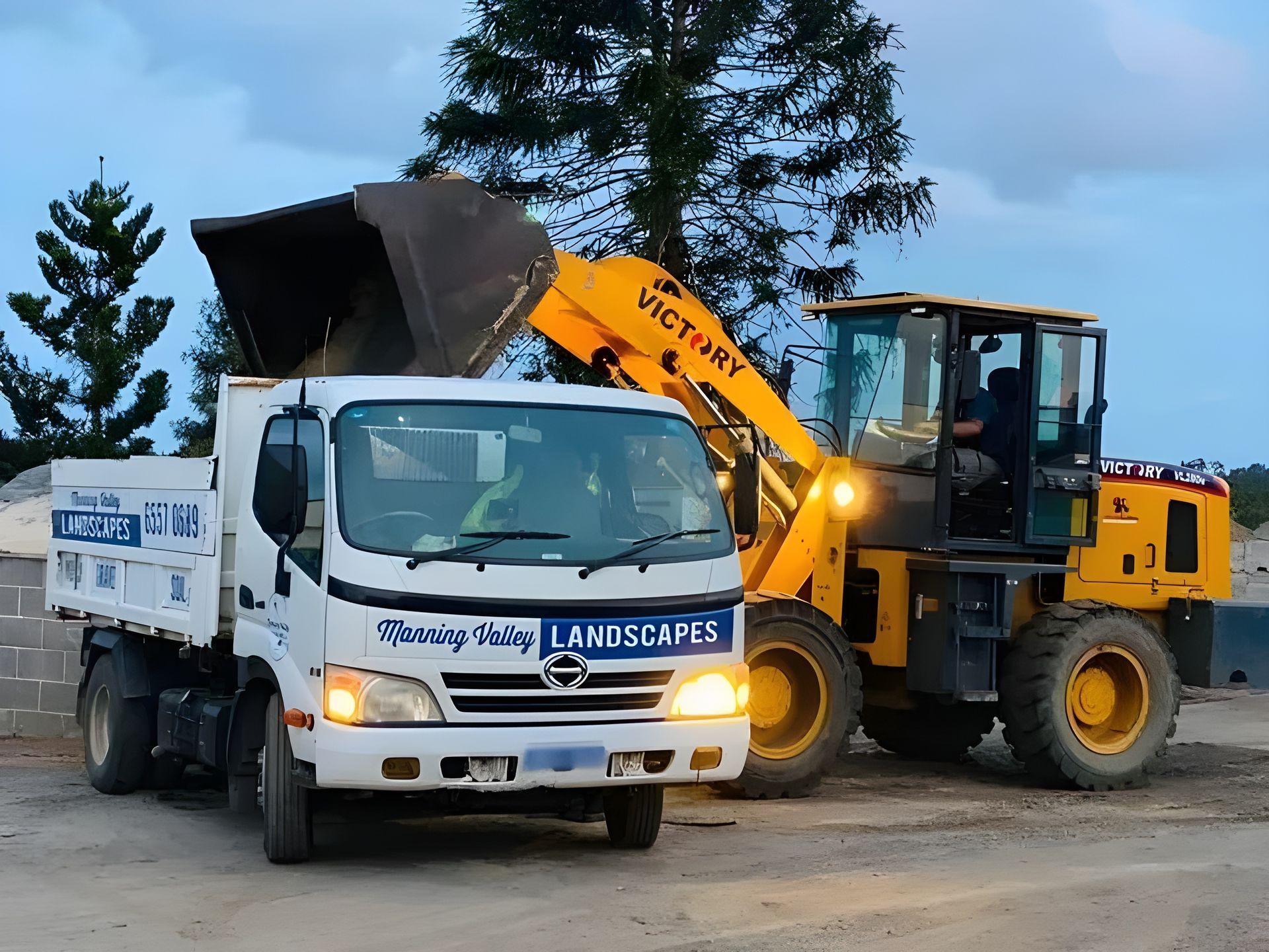 A Dump Truck and A Bulldozer Are Parked Next to Each Other — Manning Valley Landscapes in Tuncurry, NSW