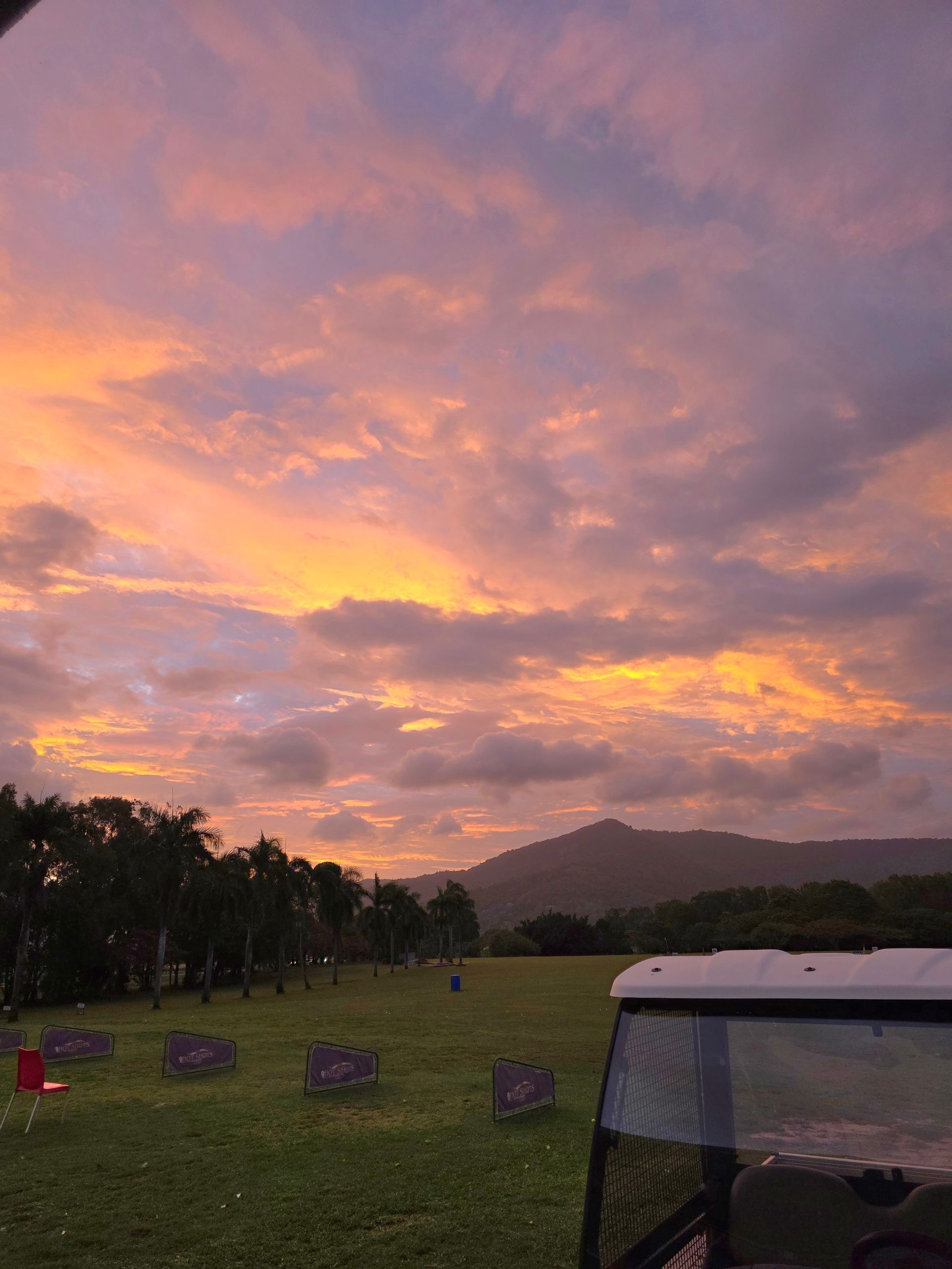 A view of a golf course from a parking lot.