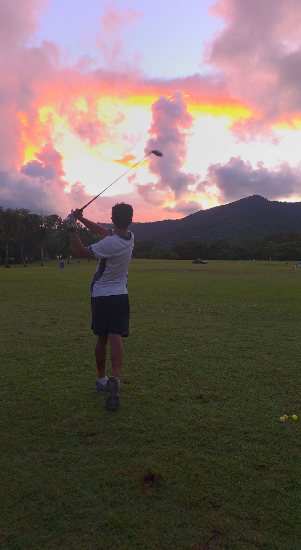 A golf course with mountains in the background and a mat in the foreground