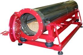 A red and steel cylindrical chamber with an open door, mounted on a red frame.